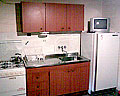 Área cocina con horno, heladera, bajo mesada y alacena en madera