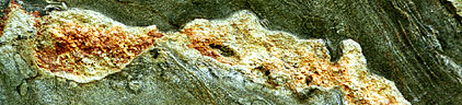 corte en la roca donde seobservan minerales verdes y naranjas